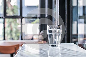 Glass of purified fresh drink water on marble table in cafe or coffee shop