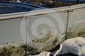glass railing with metal handle made of polished stainless steel tube.