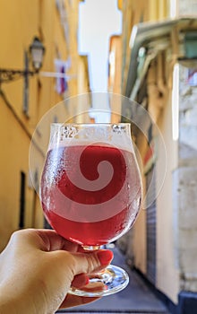 Glass of a raspberry Lambic ale at an outdoor restaurant in old town Nice France photo