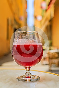 Glass of a raspberry Lambic ale at an outdoor restaurant in old town Nice France photo