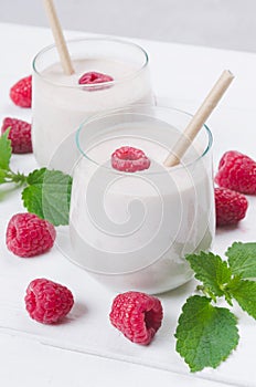 Glass of raspberry milkshake on wooden background