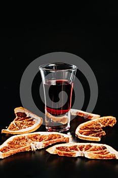 a glass of red alcoholic drink in drops