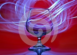 Glass on a red background with lines of light in the background