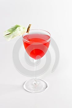 Glass with red berries cocktail on a white background. The drinks is decorated with flower