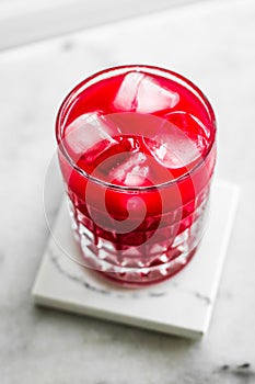 Glass of red cocktail with ice, luxury bar party