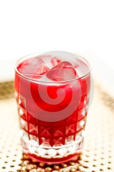 Glass of red cocktail with ice, luxury bar party