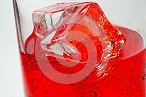 Glass of red drink with ice cl