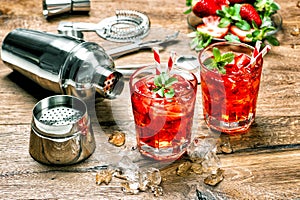 Glass of red drink with ice. Cocktail making bar tools