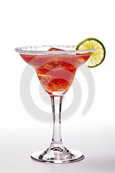 A glass of red drink with a lime wedge on top