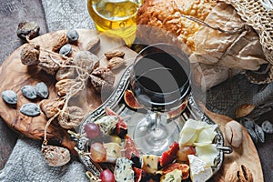A glass of red dry wine and Focaccia Italian bread with cheese and olive oil, sun-dried tomatoes and different kinds of nuts . Sel