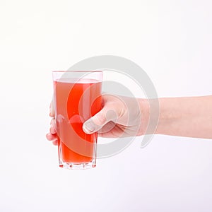 A glass with red grapefruit juice and a straw in her hand into a girl. Isolate on white background