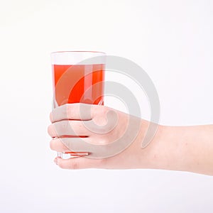 A glass with red grapefruit juice and a straw in her hand into a girl. Isolate on white background