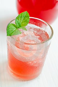 Glass of red juice (alcoholic cocktail, soft drink) with crushed ice and mint leaves