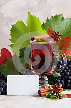 Glass of red mulled wine on beige concrete background