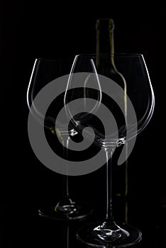 Glass of red and pink wine on a black background. Wine list menu. Close up of the power of glasses and bottles in low key