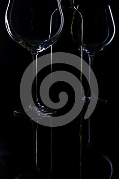 Glass of red and pink wine on a black background. Wine list menu. Close up of the power of glasses and bottles in low key