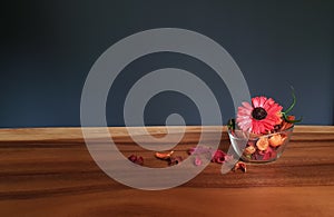 Glass of red potpourri flowers on table