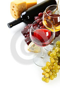 Glass of red and white wine, cheeses and grapes isolated on a white