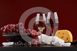 Glass of red and white wine, grapes and cheese
