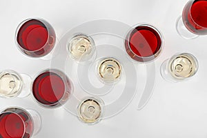 Glass of red and white wines on light background