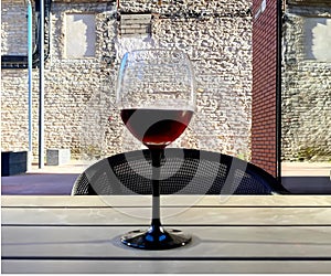 Glass of red wine against a brick wall in urban city restaurant house design art relaxing  lifestyle