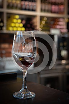 Glass of red wine on a bar in winery. Wine aroma tasting