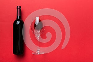 Glass of red wine and a bottle on colored table. Flat lay, top view wth copy space