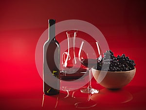 Glass red wine, bottle, grapes and pitcher photo