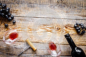 Glass of red wine and bottle on wooden background top view mock-up