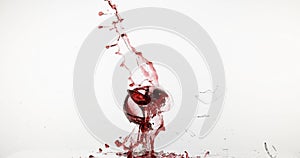 Glass of Red Wine Breaking and Splashing against White Background,