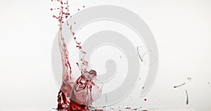 Glass of Red Wine Breaking and Splashing against White Background,