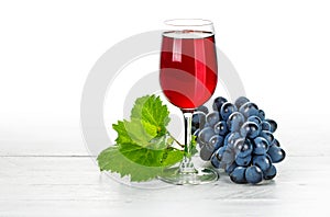 Glass red wine with cluster grapes