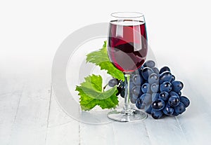 Glass red wine with cluster grapes