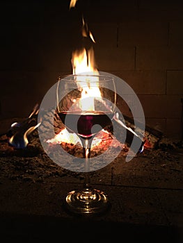 Glass of red wine with fire in the background