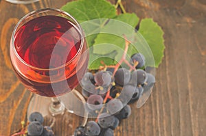 Glass of red wine and grape/glass of red wine and grape on a wooden background. Top view