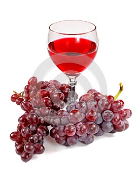 Glass of red wine and grapes clusters