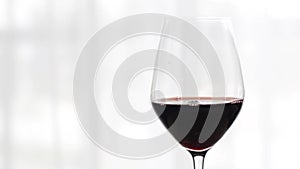 Glass of red wine indoors at wine-tasting event, holiday drink and aperitif as background for oenology and viticulture