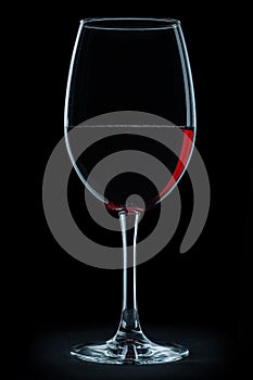 Glass with red wine isolated on black background