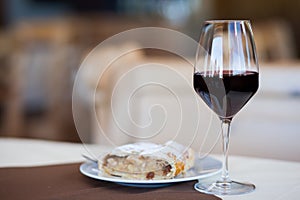 Glass of red wine and Linzer cake in cafe. Hiking in Dolomites, Italy