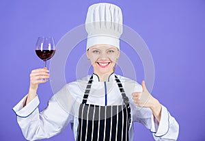 A glass of red wine is okay. Happy wine expert showing thumbs up gesture with wine glass in hand. Professional sommelier