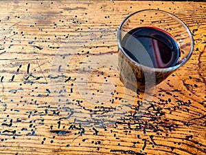 A glass of red wine on an old wooden table, view from above