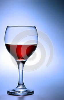 Glass of red wine over blue