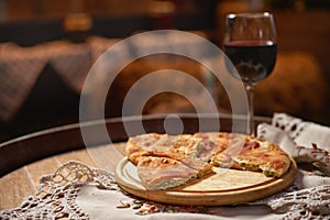 Glass of red wine and pieces of placida with cottage cheese or vertuta on a wooden tray, close-up, traditional Romanian photo