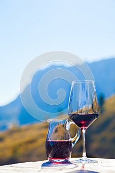 Glass of red wine on a rocky mountain background. Hiking in Dolomites, Italy