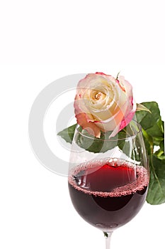 A glass of red wine with rose isolated on white photo