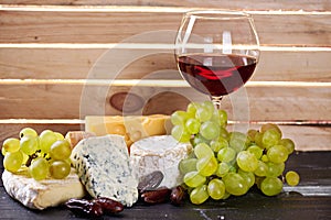 Glass of red wine, served with grapes and cheese