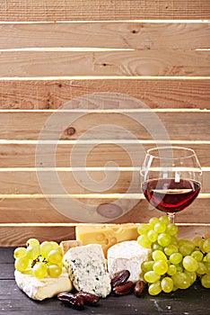 Glass of red wine, served with grapes and cheese