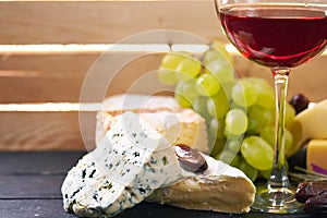 Glass of red wine, served with grapes and cheese