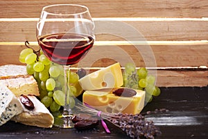 Glass of red wine, served with grapes and cheese