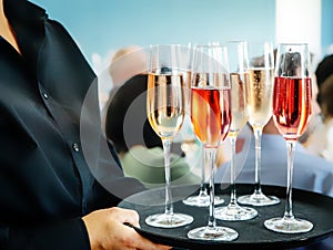 glass of red wine served by a professional caterer on blurred blue grey background